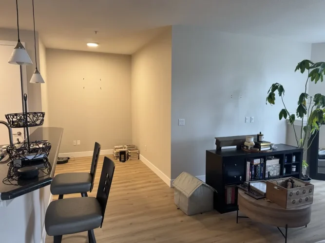 Living and dining area with walls painted to match Pale Oak, white ceilings and white baseboards.